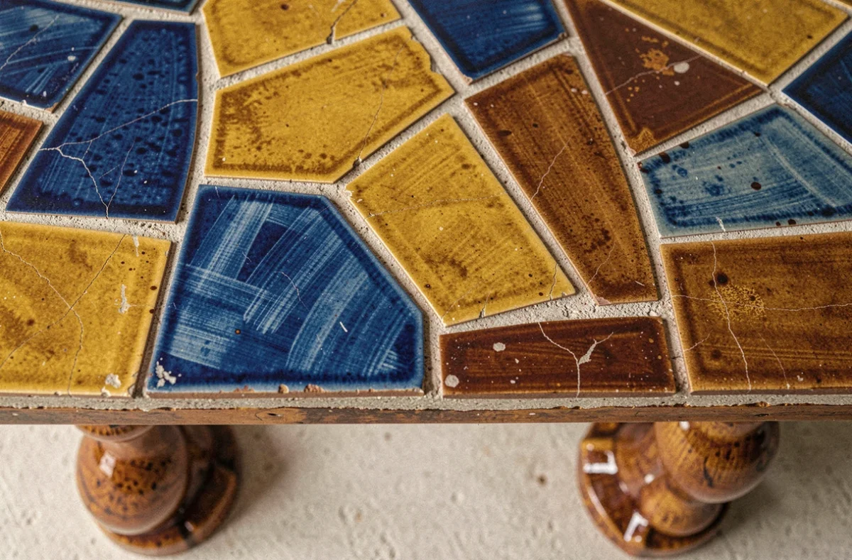 Détail du plateau en céramique mosaïque d'une table basse Capron authentique montrant les irrégularités artisanales et les émaux colorés
