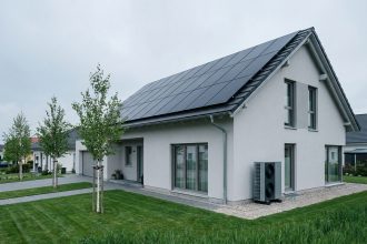 Maison neuve avec panneaux solaires sur le toit et pompe à chaleur, architecture contemporaine écoresponsable
