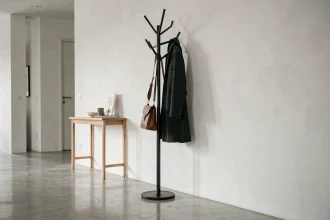 Porte manteaux moderne en métal noir mat dans une entrée minimaliste avec sol en béton poli et console en chêne